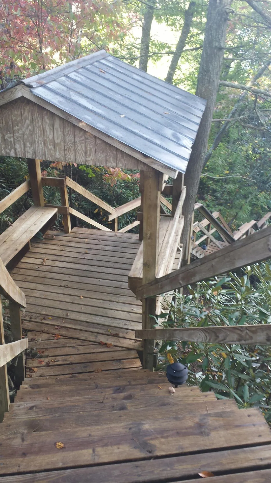 Metal roofed shelter over wooden steps on a wooded walkway — Skylight Repair & Installation work by our crew in Lynbrook