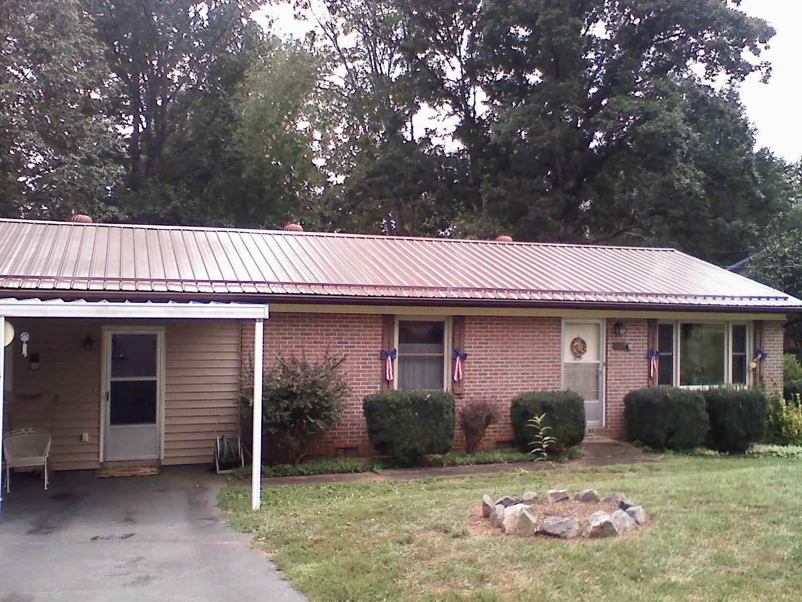 Bronze metal roof and carport on a brick ranch home — Roof Repair work by our crew in Lynbrook